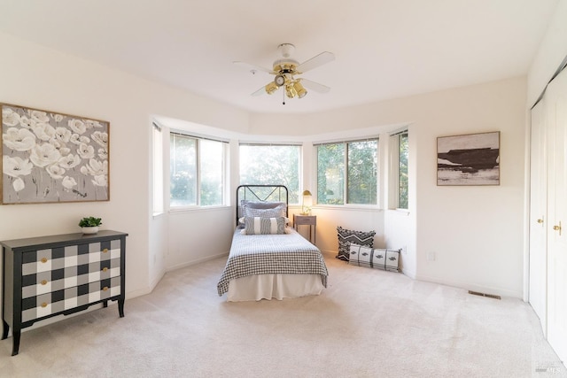 carpeted bedroom featuring a ceiling fan, baseboards, visible vents, and a closet