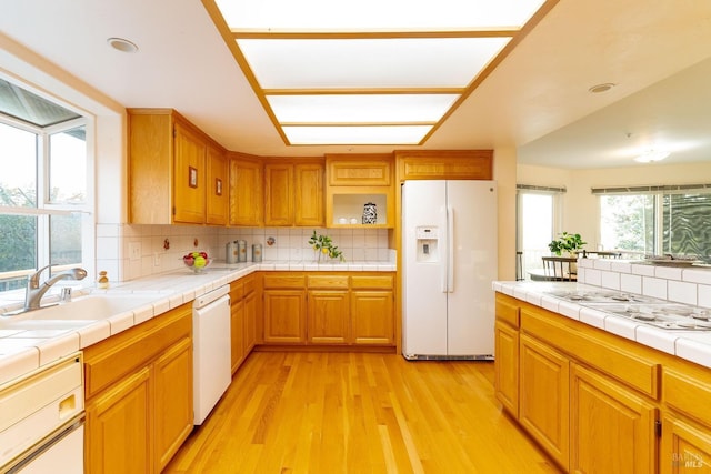 kitchen with backsplash, open shelves, a sink, white appliances, and light wood-style flooring