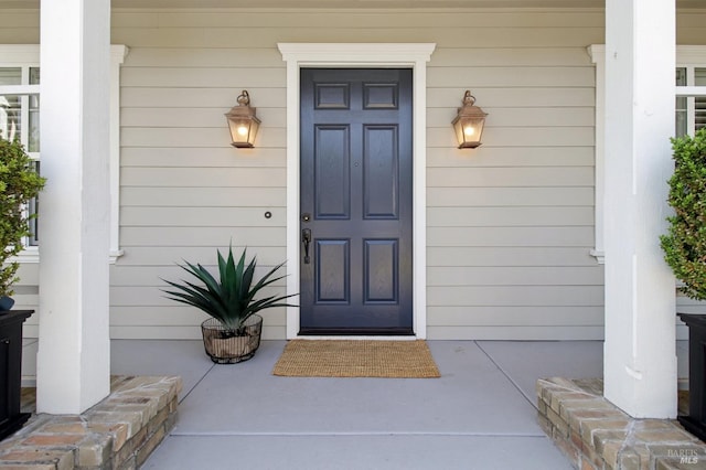 view of exterior entry featuring covered porch