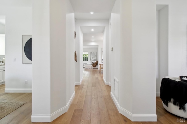 hallway featuring recessed lighting, light wood-style flooring, and baseboards