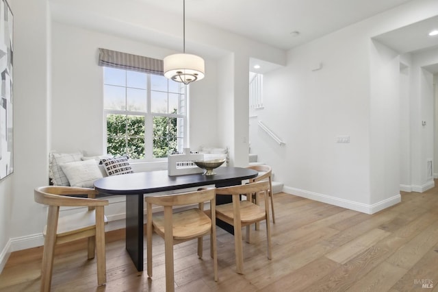 dining room featuring recessed lighting, baseboards, stairs, and light wood-style flooring