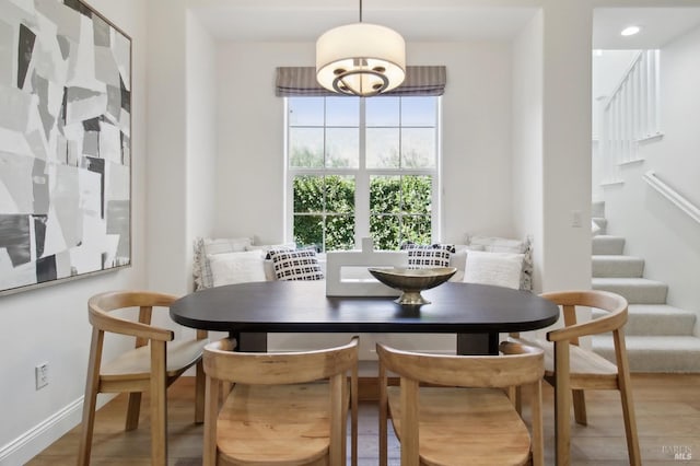 dining space with stairway, baseboards, and wood finished floors