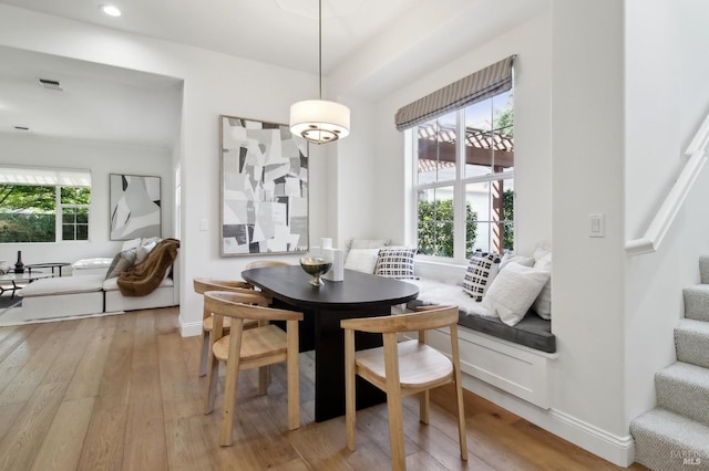 dining area featuring stairway, baseboards, light wood-style floors, and visible vents