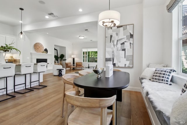 dining area with visible vents, a fireplace, light wood-style floors, baseboards, and recessed lighting