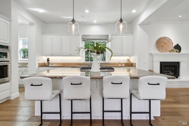 kitchen with white cabinets, a kitchen breakfast bar, and a kitchen island