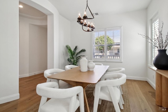 dining space with a chandelier, visible vents, plenty of natural light, and light wood-type flooring