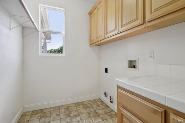 laundry area with washer hookup, hookup for an electric dryer, hookup for a gas dryer, cabinet space, and baseboards