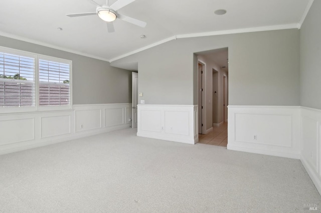 spare room featuring a wainscoted wall, ornamental molding, and light colored carpet
