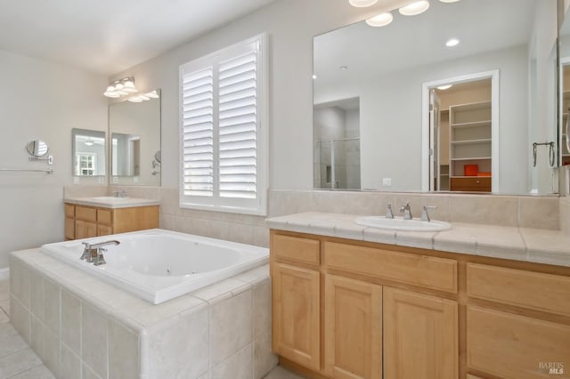 bathroom featuring vanity, tile patterned flooring, a bath, a spacious closet, and a shower stall