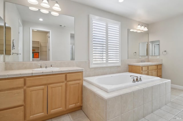 bathroom featuring a sink, tile patterned flooring, and a garden tub