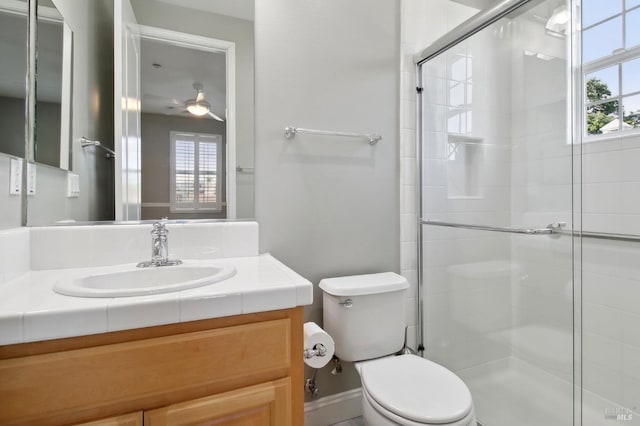 full bath with vanity, ceiling fan, a stall shower, and toilet