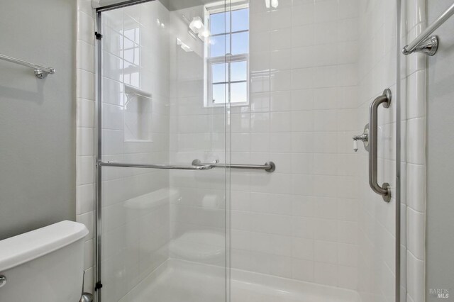 full bath featuring a shower stall and toilet