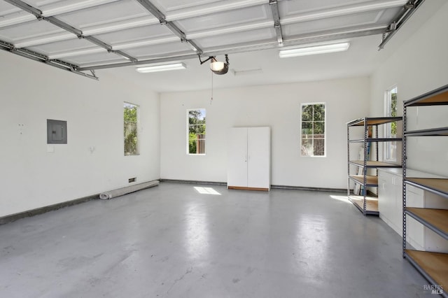 garage featuring baseboards, a garage door opener, and electric panel