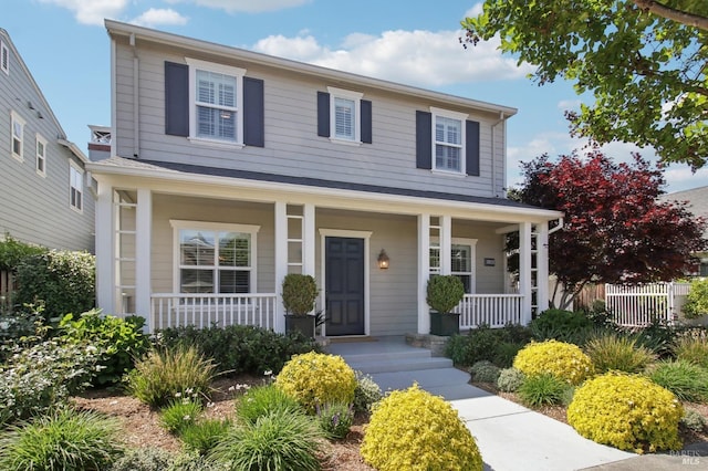 view of front of home featuring fence and a porch