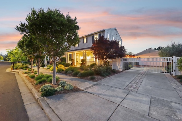 view of front of home featuring concrete driveway, fence, and a gate