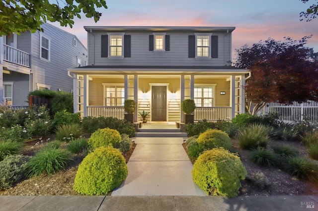 view of front facade featuring a porch and fence