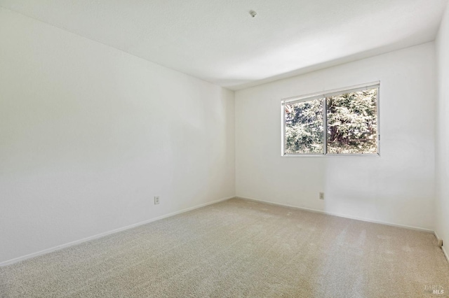 empty room with light colored carpet and baseboards