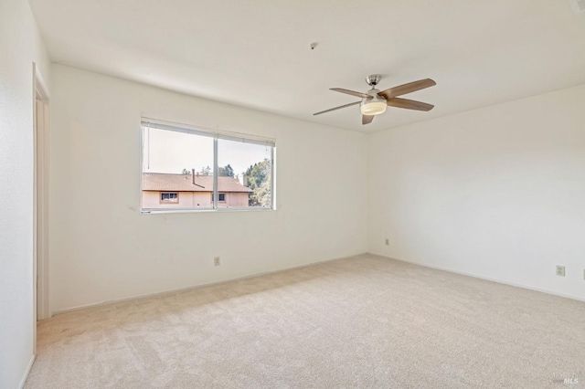 empty room with ceiling fan and light carpet