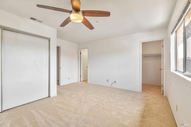 unfurnished bedroom featuring visible vents, carpet, and multiple windows