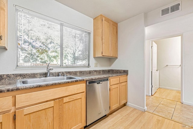 kitchen featuring stainless steel dishwasher, a sink, light brown cabinetry, and visible vents