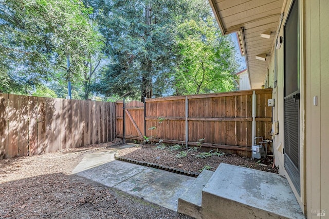 view of yard with a gate, a fenced backyard, and a patio area