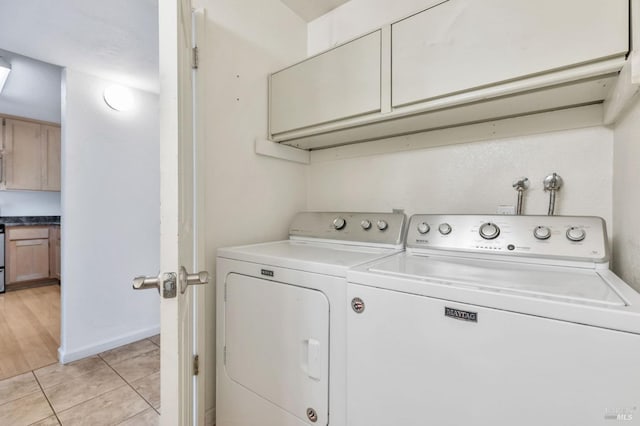 laundry area with separate washer and dryer, cabinet space, and light tile patterned floors