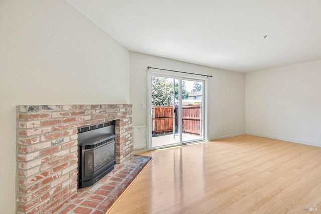 unfurnished living room with baseboards and wood finished floors