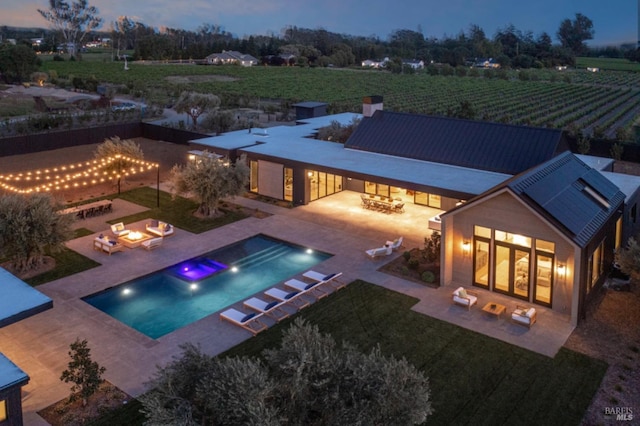 pool featuring a lawn, a patio, and a hot tub