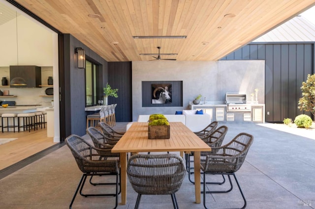 view of patio with exterior kitchen, ceiling fan, outdoor dining area, and a grill