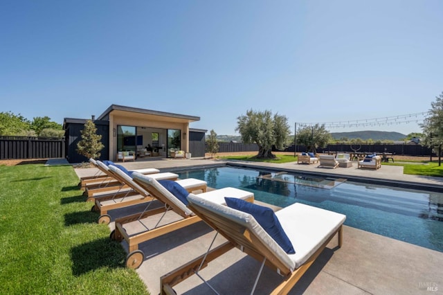 view of pool featuring a patio, a fenced in pool, a fenced backyard, an outdoor structure, and a yard