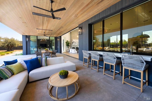 view of patio featuring an outdoor bar, outdoor dining area, a ceiling fan, and an outdoor hangout area
