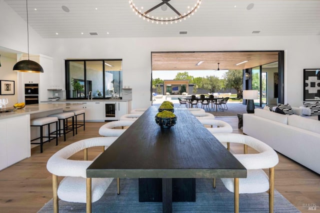 dining room with wooden ceiling, light wood-type flooring, and wine cooler
