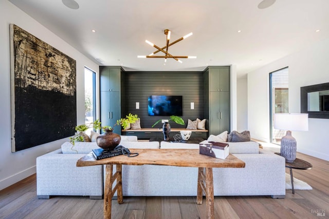 living room featuring baseboards, wood finished floors, and an inviting chandelier