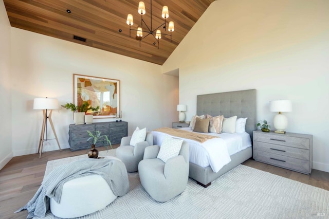 bedroom with baseboards, a chandelier, wood ceiling, and high vaulted ceiling
