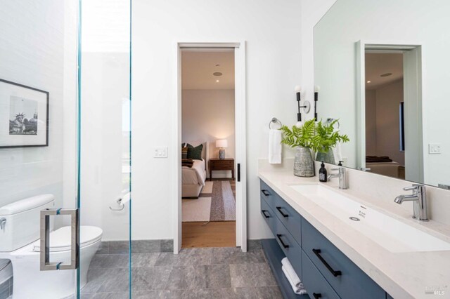 bathroom with vanity, toilet, and connected bathroom