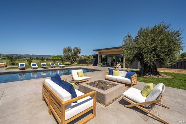 view of patio / terrace with a fenced in pool, a fenced backyard, and an outdoor living space with a fire pit