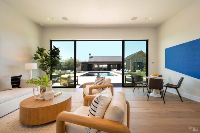 living area with light wood-style floors, recessed lighting, and a healthy amount of sunlight