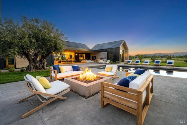 view of patio / terrace with an outdoor living space with a fire pit and an outdoor pool