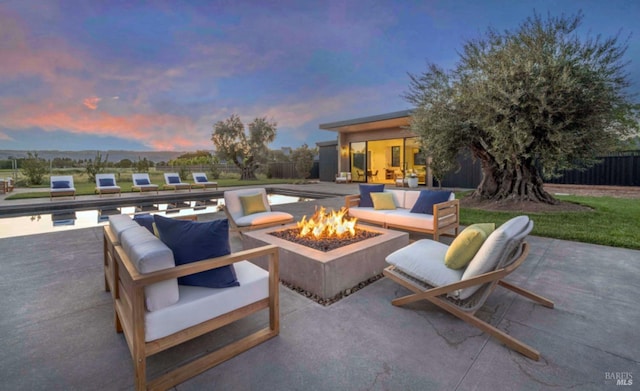 view of patio featuring fence and an outdoor living space with a fire pit