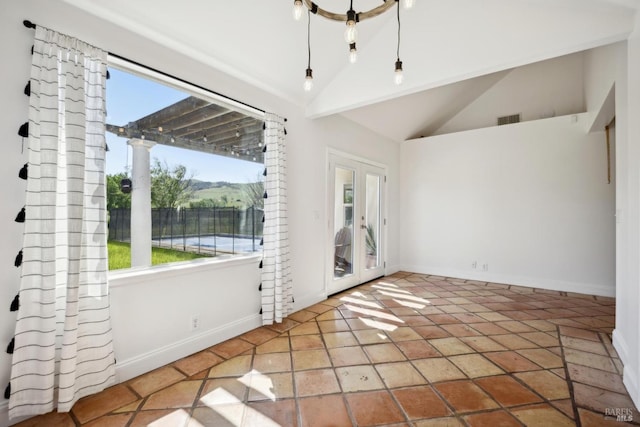 empty room with baseboards, visible vents, plenty of natural light, and lofted ceiling