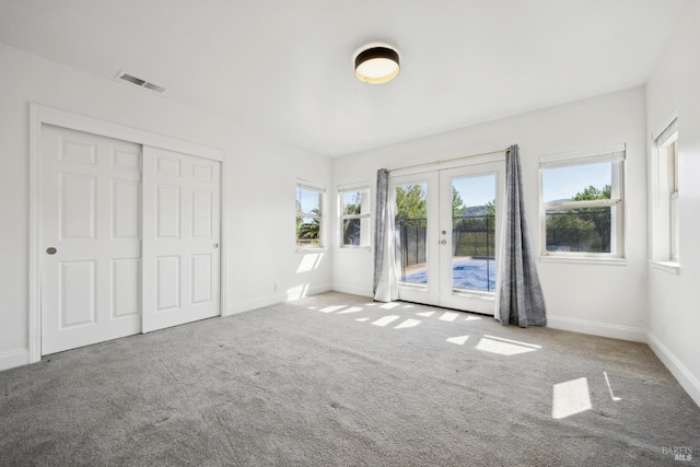 unfurnished bedroom featuring carpet floors, access to outside, french doors, and visible vents