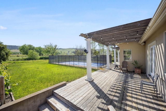 wooden terrace with a lawn, a swimming pool, a pergola, and fence