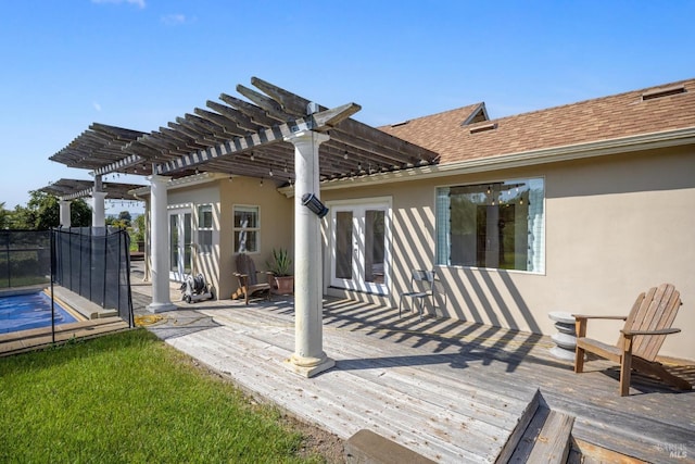 rear view of property featuring french doors, a wooden deck, a pergola, a shingled roof, and stucco siding