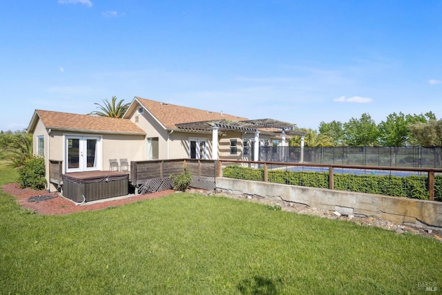 back of property featuring french doors, a hot tub, a yard, a pergola, and stucco siding