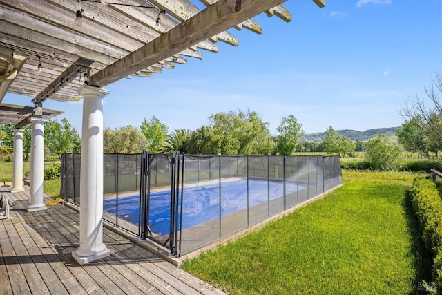 view of pool featuring a yard, a pergola, a fenced in pool, and a mountain view