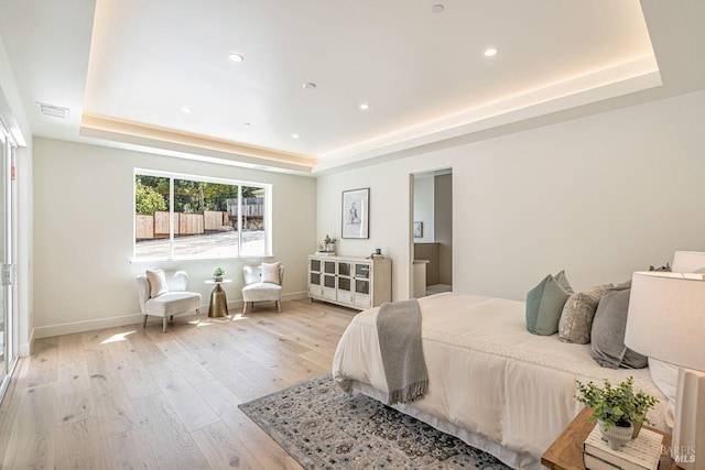 bedroom with recessed lighting, a raised ceiling, baseboards, and light wood-type flooring