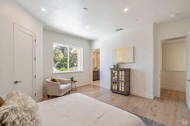 bedroom with visible vents, light wood-style floors, and baseboards