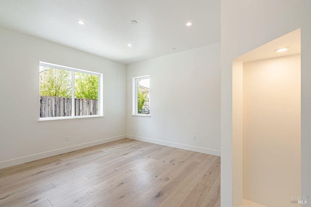 spare room featuring recessed lighting, baseboards, and light wood-style flooring