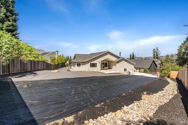 back of property with a fenced backyard and a deck