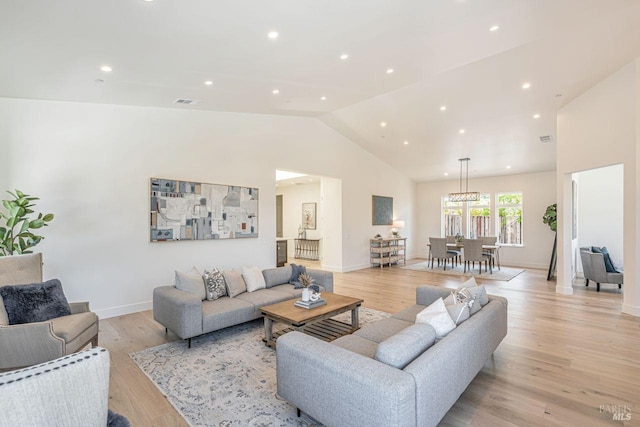 living area with recessed lighting, baseboards, a chandelier, and light wood-style floors